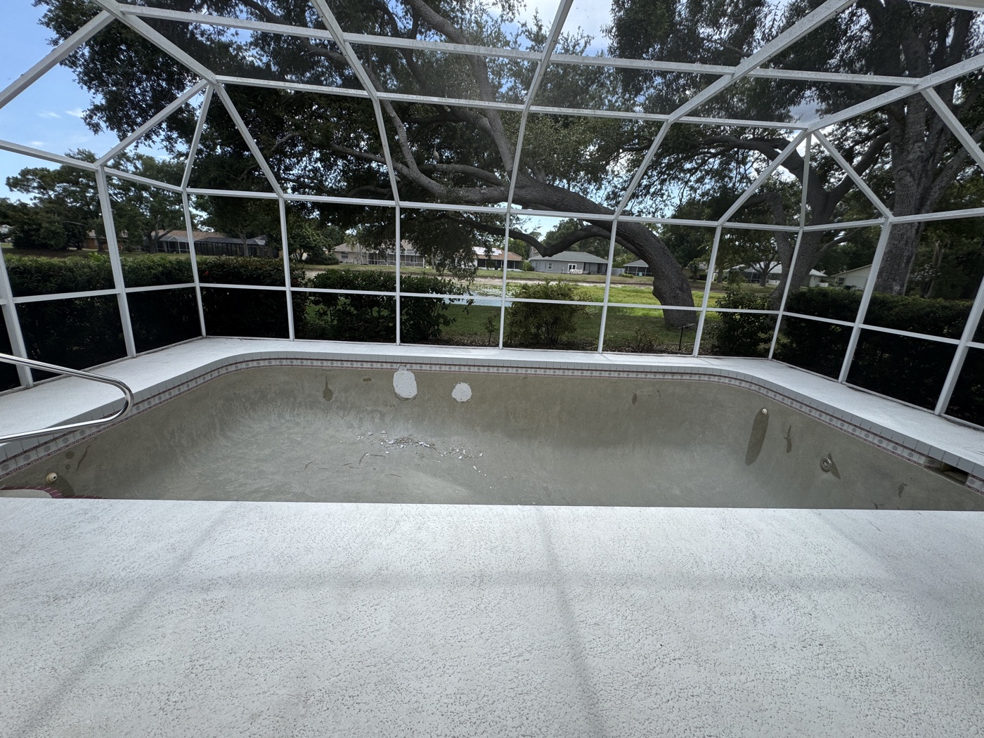 Drained pool with a worn, stained interior before renovation — Sarasota pool remodel